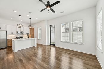 A modern kitchen with a wooden floor and white walls at The Hadley - North Port, FL Apartments, North Port, Florida